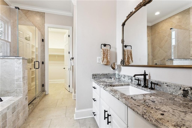 bathroom with a walk in closet, a stall shower, vanity, baseboards, and ornamental molding