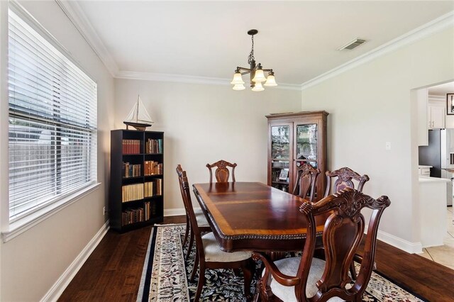 dining space with wood-type flooring, a notable chandelier, visible vents, and a healthy amount of sunlight