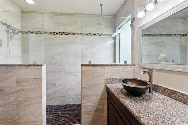 full bathroom with vanity, a walk in shower, and tile walls