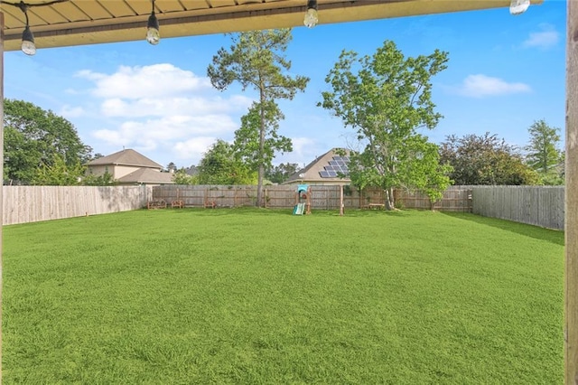 view of yard with a playground and a fenced backyard