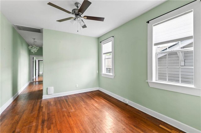 spare room with baseboards, ceiling fan, hardwood / wood-style floors, and visible vents