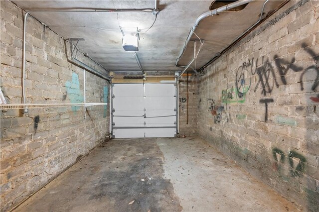 garage with concrete block wall and a garage door opener
