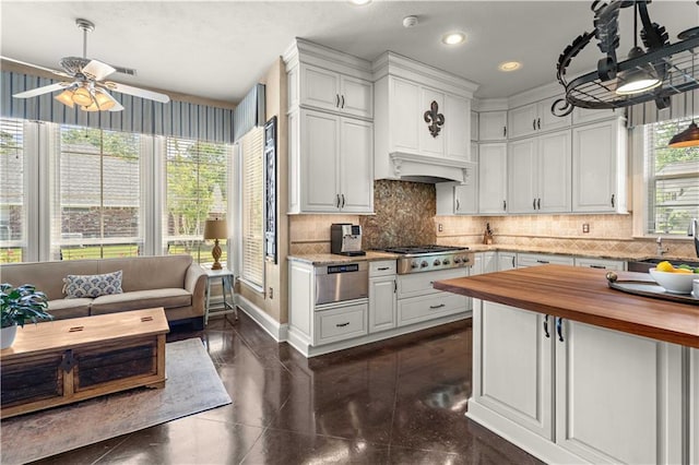 364 Winchester Cir, Mandeville, LA 70448 - kitchen featuring stainless steel gas cooktop, ceiling fan, white cabinetry, wood counters, and backsplash