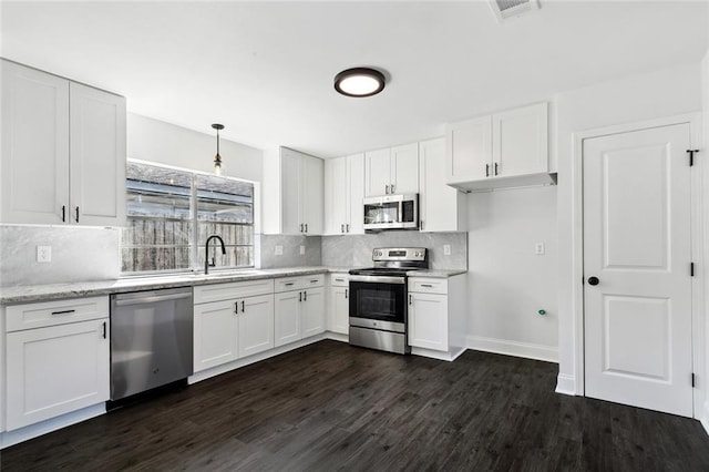 314 Raleigh Dr, Slidell, LA 70460 - kitchen with stainless steel appliances, dark wood-type flooring, backsplash, white cabinets, and pendant lighting