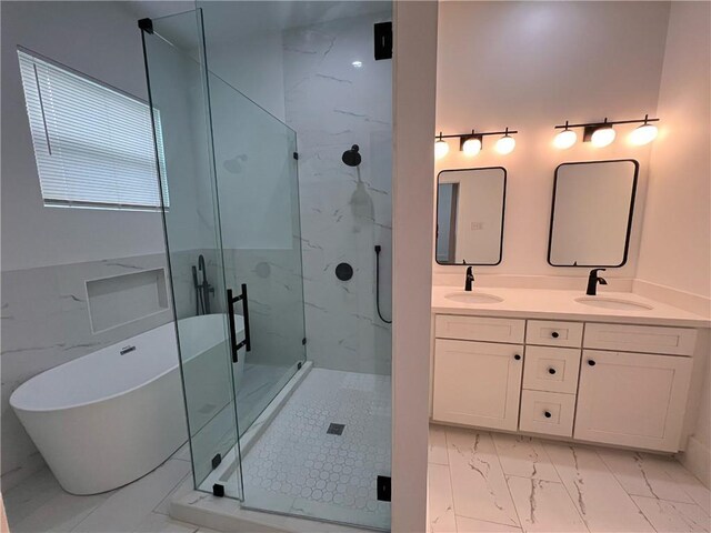 full bath with a sink, a marble finish shower, a freestanding bath, and marble finish floor