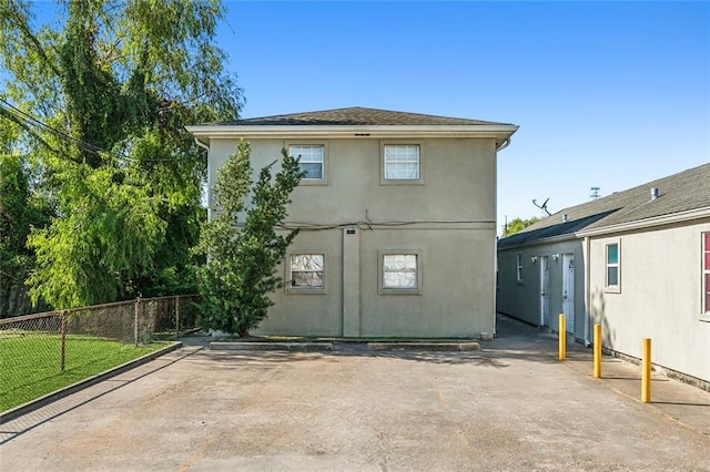 exterior space with fence, a patio, stucco siding, and a lawn