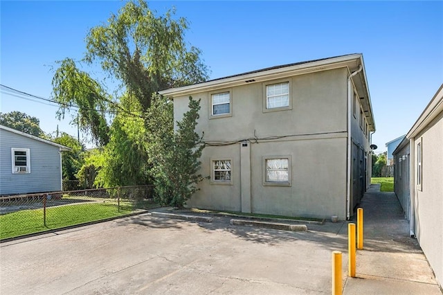 rear view of property featuring stucco siding, a patio area, and fence
