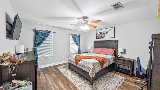 bedroom with visible vents, baseboards, ceiling fan, and wood finished floors