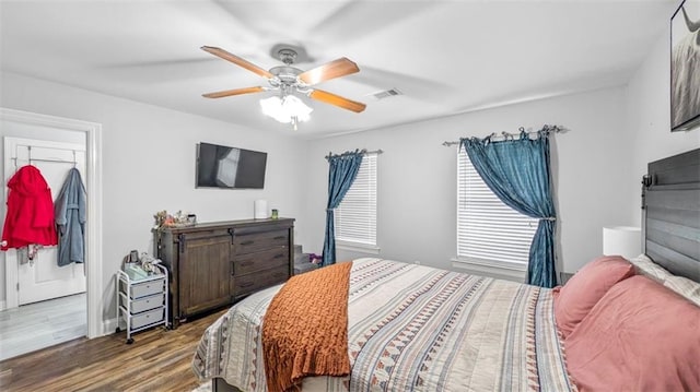 bedroom with visible vents, ceiling fan, wood finished floors, and multiple windows