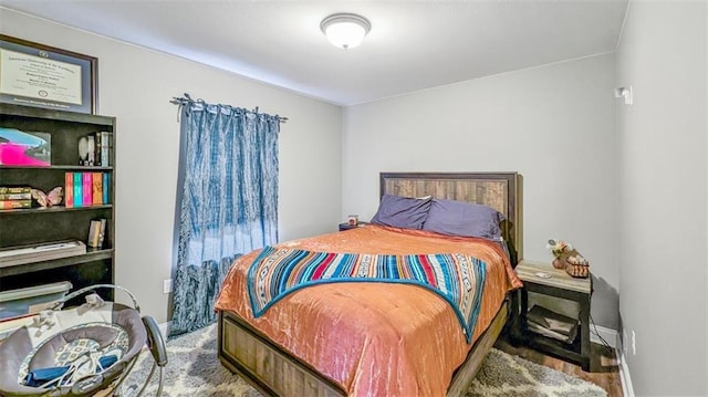 bedroom featuring baseboards and wood finished floors