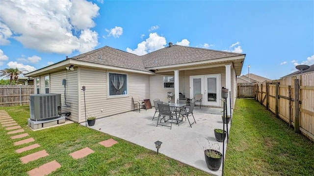 back of house with a fenced backyard, roof with shingles, french doors, central air condition unit, and a yard