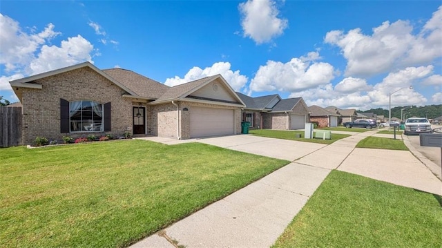 view of front of property with a front lawn, fence, brick siding, an attached garage, and driveway