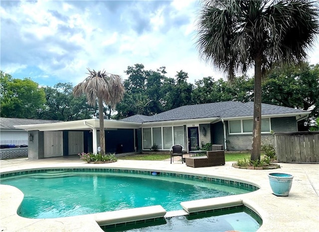 view of pool with a patio, a pool with connected hot tub, and fence