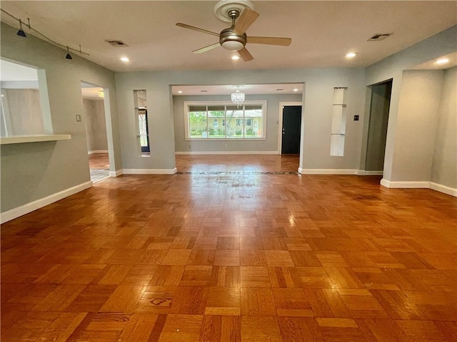 unfurnished room featuring visible vents, a ceiling fan, and baseboards
