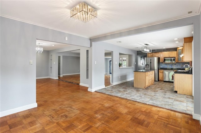 19 Rail St, New Orleans, LA 70124 - kitchen featuring a chandelier, stainless steel appliances, baseboards, dark countertops, and a center island