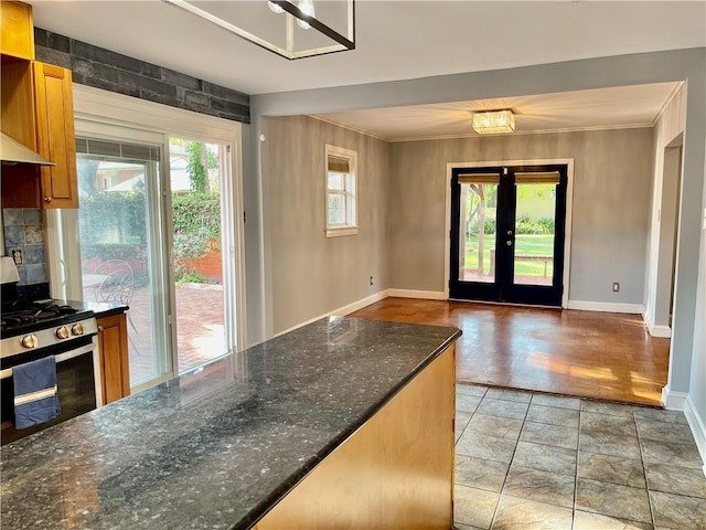 doorway featuring baseboards, ornamental molding, and french doors
