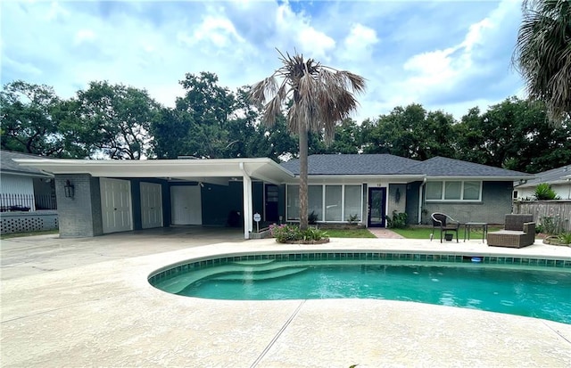 pool with a patio area and fence