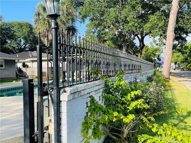 view of gate with a fenced in pool and fence