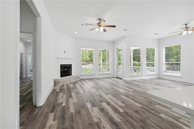 unfurnished living room featuring baseboards, ceiling fan, a healthy amount of sunlight, and wood finished floors
