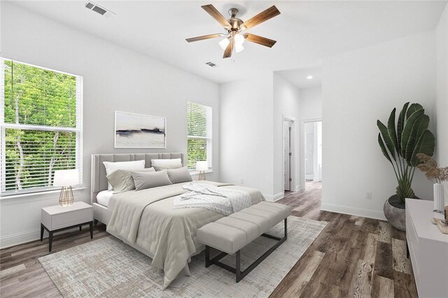 bedroom featuring baseboards, wood finished floors, and visible vents