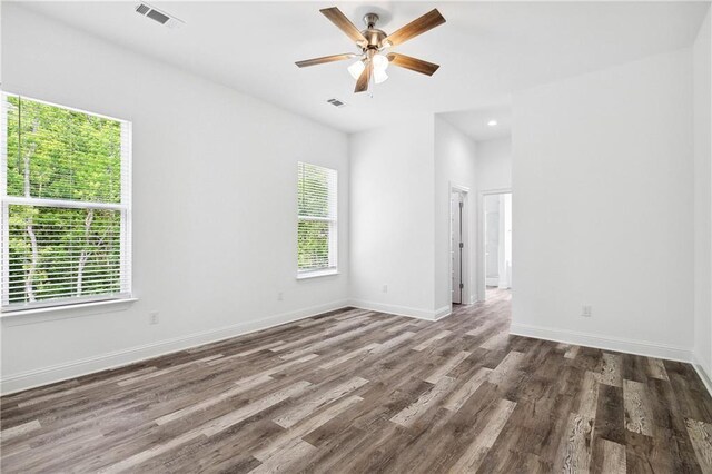 spare room with visible vents, baseboards, ceiling fan, and wood finished floors