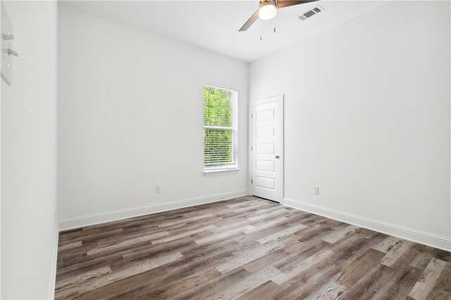 spare room with visible vents, baseboards, ceiling fan, and wood finished floors