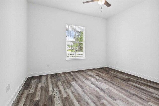 spare room featuring baseboards, ceiling fan, and wood finished floors