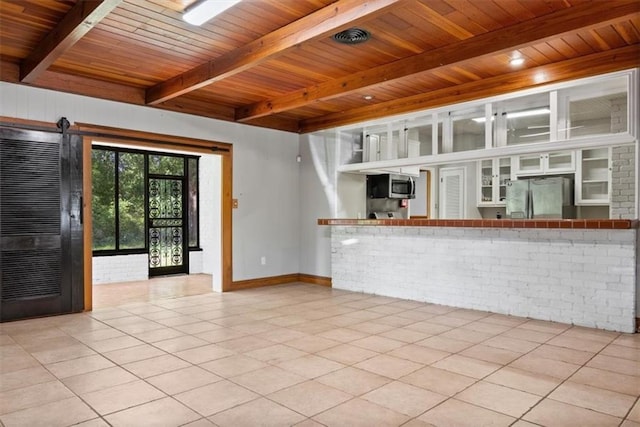unfurnished living room with tile patterned floors, brick wall, baseboards, wooden ceiling, and beamed ceiling
