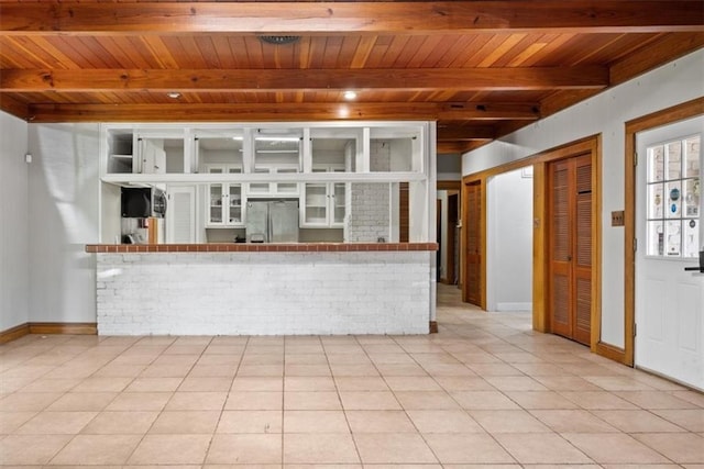 unfurnished living room with beam ceiling, light tile patterned flooring, and wooden ceiling