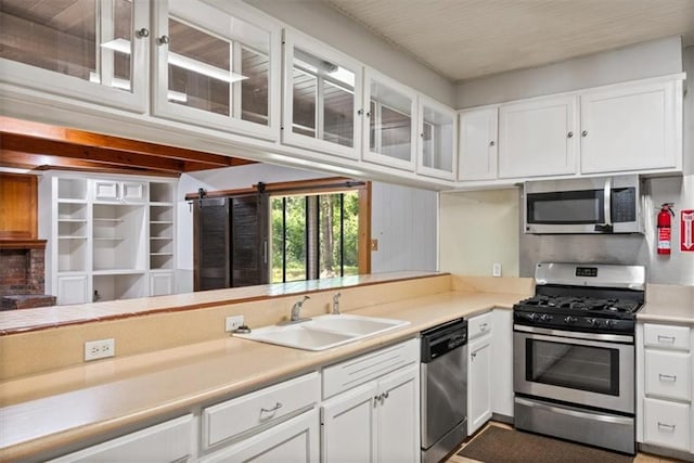 kitchen with a sink, stainless steel appliances, and white cabinetry