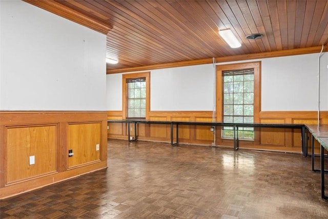 interior space with wainscoting, a healthy amount of sunlight, and wooden ceiling