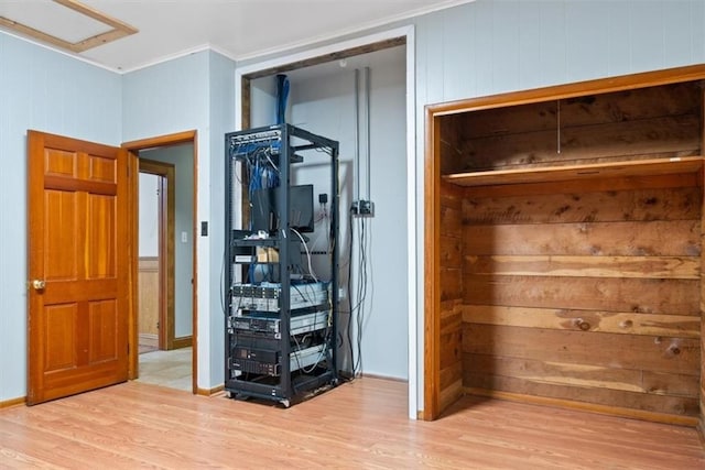 unfurnished bedroom with baseboards, ornamental molding, and light wood-type flooring