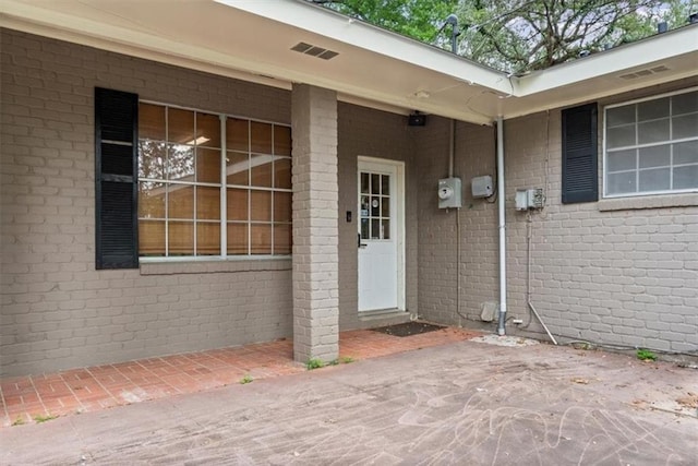 entrance to property featuring brick siding