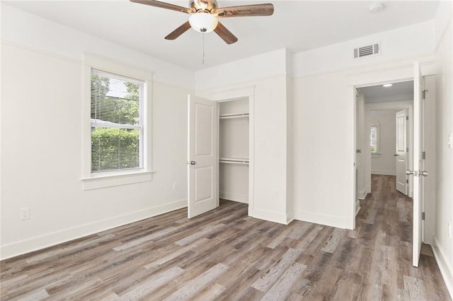 unfurnished bedroom with visible vents, a ceiling fan, light wood-style flooring, and baseboards