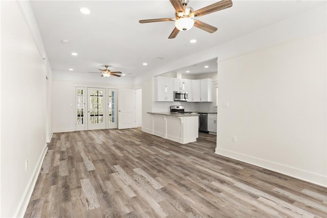 unfurnished living room with light wood-style floors, a ceiling fan, baseboards, and recessed lighting