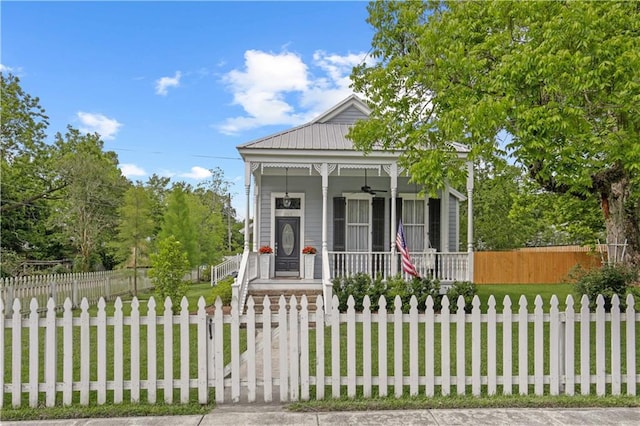 shotgun-style home featuring a fenced front yard, covered porch, and a front yard