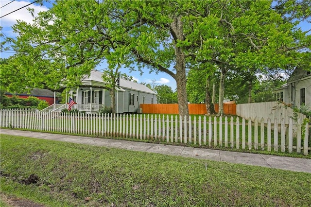 exterior space with a fenced front yard and a front lawn