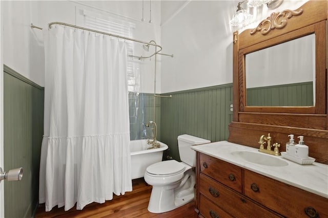 full bath with vanity, wainscoting, wood finished floors, toilet, and shower / bathtub combination with curtain