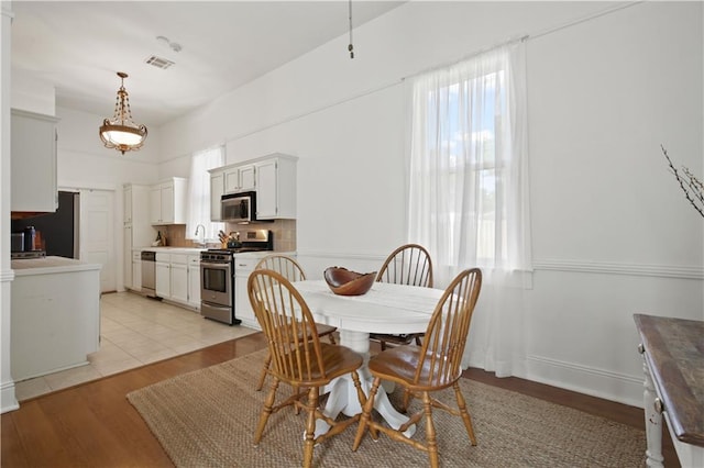 dining space featuring visible vents and light wood finished floors