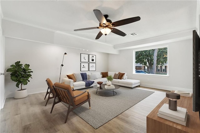 living area with baseboards, ceiling fan, light wood-type flooring, and visible vents