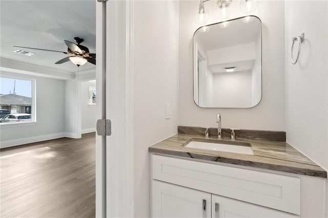 bathroom featuring vanity, a ceiling fan, baseboards, wood finished floors, and visible vents