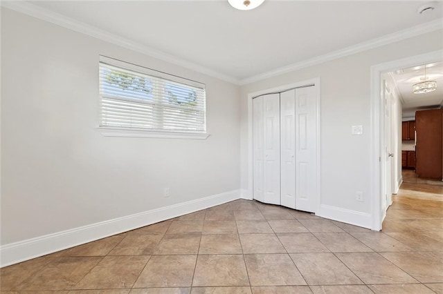 unfurnished bedroom featuring crown molding, light tile patterned flooring, baseboards, and a closet