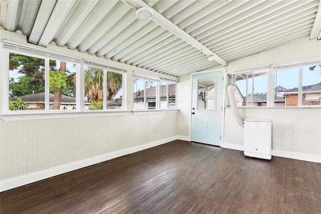 unfurnished sunroom with baseboards, lofted ceiling with beams, wood finished floors, and a healthy amount of sunlight