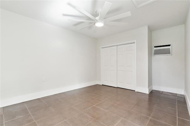 unfurnished bedroom with a ceiling fan, baseboards, a wall mounted AC, and a closet