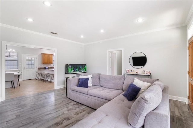 living room featuring crown molding, light wood-style flooring, recessed lighting, baseboards, and visible vents