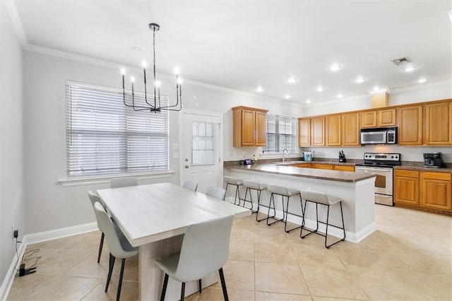 kitchen with a kitchen breakfast bar, visible vents, crown molding, a chandelier, and stainless steel appliances