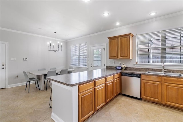 kitchen featuring brown cabinetry, dark countertops, dishwasher, a sink, and a notable chandelier