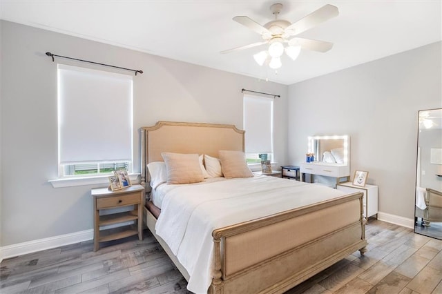 bedroom featuring light wood-style floors, a ceiling fan, and baseboards
