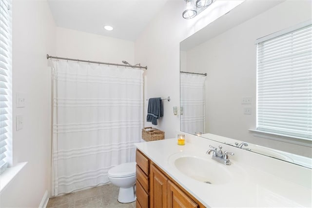 full bath with vanity, a healthy amount of sunlight, and toilet