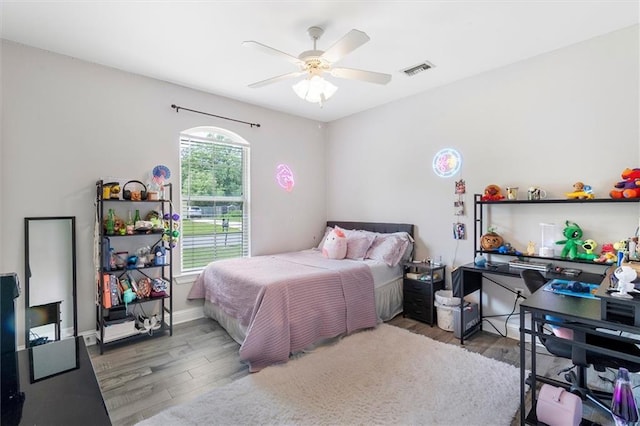 bedroom with visible vents, baseboards, ceiling fan, and wood finished floors